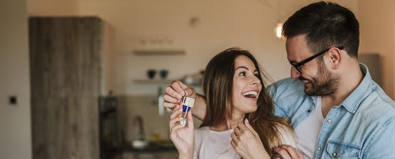 Young man surprising his wife or a girl with new a apartment.